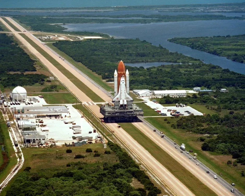 Aerial photograph of Space Shuttle Challenger on the crawler-transporter heading to the launch pad at Kennedy Space Center before its final flight, STS-51-L.