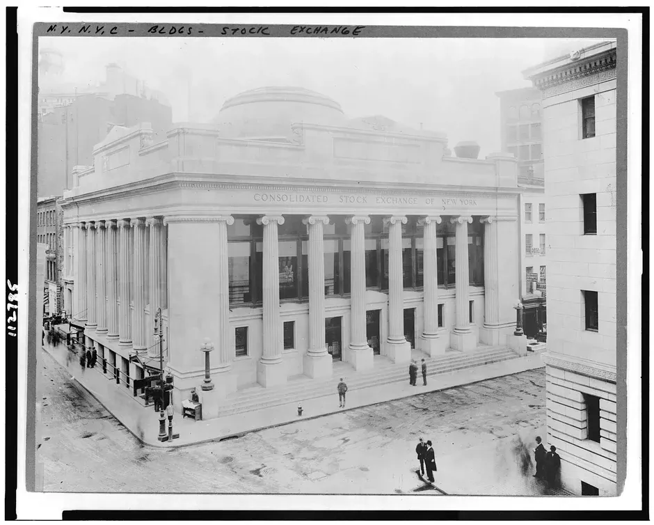 Vintage photograph of the exterior of the New York Stock Exchange building on Wall Street, with its iconic neoclassical facade and columned entrance.